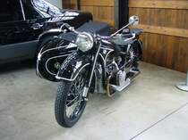 BMW R12 Gespann aus dem Jahr 1935. Die R12 wurde 1935 auf der Internationalen Berliner Automobilausstellung vorgestellt. Mit einem Beiwagen war die R12 und die R75 das Standardgespann der Deutschen Wehrmacht im Zweiten Weltkrieg. Bis zum Produktionsende im Jahr 1942 verließen ca. 36.000 R12 Motorräder die Werkshallen in München. Der Zweizylinderboxermotor hat einen Hubraum von 746 cm³ und leistet, je nach Vergaserbestückung, zwischen 18 PS und 20 PS. Classic Remise Düsseldorf am 07.06.2021.