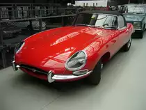 Jaguar E Type Roadster. Der E Type Roadster, ein Klassiker par excellence im Farbton carmen red. Vorgestellt wurde das Modell auf dem Genfer Salon des Jahres 1961. Wie schon 13 Jahre zuvor der XK120 stieß auch der E Type in der Fachpresse auf einhellige Begeisterung. Sowohl der hier gezeigte Roadster, als auch das FHC (Fixed Head Coupe) genannte, geschlossene Modell, waren sofort der Traumwagen der breiten, automobilen Masse. Obwohl die Warteliste bzw. Lieferzeit lang war, bot der damalige Jaguar-Boss William Lyons den Wagen zu einem unerwartet günstigen Preis an. Der Sechszylinderreihenmotor der Series I-Fahrzeuge hat einen Hubraum von 3781 cm³ und leistet 265 PS. Die Höchstgeschwindigkeit des Series I betrug 237 km/h. Classic Remise Düsseldorf am 07.06.2021.
