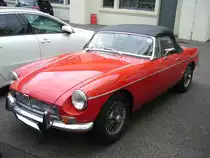 MG B im Farbton flame red aus dem Modelljahr 1971. Der MG B wurde 1962 vorgestellt und bis 1980 produziert. Er war einer der erfolgreichsten Roadster der Automobilgeschichte. Der Vierzylinderreihenmotor leistet 95 PS aus 1798 cm³ Hubraum. Besucherparkplatz der Düsseldorfer Classic Remise am 07.06.2021.