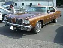 Oldsmobile 98 Luxury aus dem Modelljahr 1974 im Farbton ciation bronce. Angetrieben wird der Wagen von einem V8-Motor der aus einem Hubraum von 7446 cm³ eine Leistung von ca. 220 PS an die Hinterachse weiter gibt. Oldtimertreffen an Mo´s Bikertreff in Krefeld am 27.06.2021.