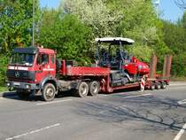 Ein 3344er von Mercedes-Benz steht mit einem neuen  Asphaltfertiger Super 1600-2 von V�gele auf dem Tieflader und wartet darauf abgeladen zu werden.