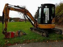 CAT 303.5E; rahmt sozusagen mit seinem Arbeitsarm bei Aurachkirchen die beiden vorbeifahrenden E-Loks (1144099-9+1142631-1); 201030