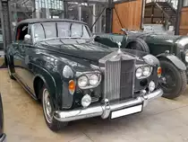 Rolls Royce Silver Cloud III Convertible, gebaut von 1962 bis 1965. Als der Silver Cloud III im Jahr 1962 vorgestellt wurde, fiel dem Fachpublikum als erstes der Wechsel zu Doppelscheinwerfern und eine niedriger geführte Linie der vorderen Kotflügel und der Motorhaube auf. Zum ersten Mal konnte auch für das Chassis des Rolls-Royce für den Aufbau einer Coupé- oder Cabriolet-Varianten bestellt werden, die bis dato exklusiv dem fast baugleichen Bentley Continental vorbehalten war. Der V8-Motor hat einen Hubraum von 6230 cm³ und leistet 187 PS. Dieser, im Farbton velvet green lackierte Silver Cloud III wurde 1964 gebaut und ist nur einer von 25 produzierten, linksgelenkten Silver Cloud III Convertible. Ein Vorbesitzer dieses Fahrzeuges ist der US-amerikanische Schauspieler Nicolas Cage. Classic Remise Düsseldorf am 11.08.2021.