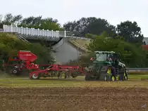 Ein John Deere 8RX Traktor mit Raupenfahrwerk und Horsch Pronto 6 TD Sämaschine auf Grubber Tiger LT war Mitte August 2021 bei Breechen unterwegs.