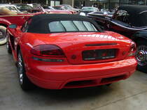 Heckansicht einer Dodge Viper SRT-10 Roadster. Auf Basis der 1992 vorgestellten  Viper  kam im Jahr 2003 die  Viper SRT-10  auf den Markt. Das SRT stand für S treet and R acing T echnology. Mit der Modellreihe SRT-10 war jetzt auch ein Cabrioletmodell lieferbar. Die Motorleistung ist einfach nur brutal. Ein V10-Motor mit einem Hubraum von 8285 cm³/506 PS oder 8383 cm³/612 PS. Classic Remise Düsseldorf am 21.10.2021.