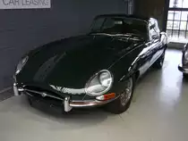 Jaguar E-Type Series 1 Coupe. Der E Type, ein Klassiker par excellence im Farbton opalescent grey. Vorgestellt auf dem Genfer Salon des Jahres 1961. Wie schon 13 Jahre zuvor der XK120 stieß auch der E Type in der Fachpresse auf einhellige Begeisterung. Sowohl Cabriolet, als auch das FHC (Fixed Head Coupe) genannte, geschlossene Modell waren sofort der Traumwagen der breiten, automobilen Masse. Obwohl die Warteliste bzw. Lieferzeit lang war, bot der damalige Jaguar-Boss William Lyons den Wagen zu einem unerwartet günstigen Preis an. Der Sechszylinderreihenmotor des Series I hat einen Hubraum von 3781 cm³ und leistet 265 PS. Die Höchstgeschwindigkeit des Series I betrug 237 km/h. Classic Remise Düsseldorf am 16.12.2021.
