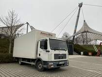 MAN TGL von Arena One, im Hintergrund ist ein Teil der Zeltdachkonstruktion des Olympiaparks München, Februar 2022