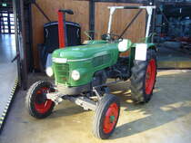 Fendt Fix 2, gebaut von 1959 bis 1964. Er war der Nachfolger des ein Jahr vorher vorgestellten Fendt Fix 1. Die Scheinwerfer waren jetzt, wie bei den großen Modellen Farmer und Favorit, in die Kühlerhaube integriert. Auch die Motoren hatten sich geändert. Es wurden Zweizylindermotoren der Marke MWM eingebaut, die wahlweise mit Luft- oder Wasserkühlung bestellt werden konnten. Das Getriebe und die meisten anderen Ausstattungsdetails wurden vom Vorgänger übernommen. Neu waren als optionales Zubehör, ein Allwetterverdeck mit Frontscheibe, eine Seilwinde und die Startostop-Einrichtung. Hiermit konnte der Schlepper mit einen Handhebel ohne aufzusteigen vom Boden aus angefahren und gestoppt werden. Die luftgekühlte Version hat einen Hubraum von 1107 cm³ und leistet 20 PS. Die Version mit Wasserkühlung hat einen Hubraum von 1650 cm³ und leistet ebenfalls 20 PS. Classic Remise Düsseldorf am 13.02.2022.