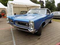 Pontiac GTO Convertible des Modelljahres 1966. Das Modell GTO war von 1964 bis 1974 eine eigenständige Modellreihe im Verkausprogramm der GM-Division Pontiac. Der Wagen war als Coupe oder Convertible (Cabriolet) lieferbar. Von diesem Cabrioletmodell verkaufte Pontiac im Jahr 1966 genau 12.798 Fahrzeuge zu einem Preis ab US$ 3425,00. Der V8-Motor hat einen Hubraum von 6361 cm³ und konnte wahlweise mit einem Doppelvergaser = 340 PS oder drei Doppelvergasern = 365 PS bestellt werden. Der abgelichtete GTO ist im Farbton fontaine blue lackiert. Classic Festival auf Schloss Lembeck im Juli 2019.