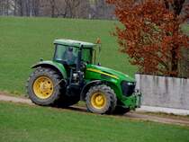 John Deere-7720 braust im Morgengrauen auf dem abfallenden Versorgungsweg in Richtung Dieseltankstelle; 220226