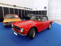 Triumph TR6 im Farbton signalred, produziert in den Jahren von 1970 bis 1975. Im Jahr 1970 erschien der letzte Abkömmling der klassischen Triumph TR-Baureihe in Form des TR6. Die Karosserie hatte der legendäre Giovanni Michelotti (*1921 +1980) gezeichnet. Der Sechszylinderreihenmotor des TR6 stammt vom Triumph 2000 und wurde auf 2498 cm³ Hubraum aufgebohrt. Dieser Motor leistet 150 PS und beschleunigt den TR6 auf eine Höchstgeschwindigkeit von 190 km/h. Dieser TR6 steht allerdings auf nicht so ganz zeitgenössischen Felgen. Techno Classica Essen am 27.03.2022.
