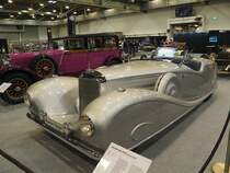 Auf der Berliner Automobilausstellung 1935 hat die Berliner Karosserieschmiede Erdmann & Rossi einen sensationellen Mercedes Benz W29 mit offener Stromlinienkarosserie und voll verkleideten Rädern gezeigt. Ende des Jahres 1935 wurde dann ein 500 K mit einem entsprechenden Aufbau an das irakische Königshaus ausgeliefert. Dieses Fahrzeug ist nach wie vor im irakischen Staatsdepot in Bagdad beheimatet. Das Fahrzeug auf dem Bild ist eine Reproduktion, die vermutlich 1986 durch die Firma Reifen Wagner auf dem Fahrgestell eines 500 K Cabrio A aufgebaut wurde. Der Achtzylinderreihenmotor hat einen Hubraum von 5018 cm³ und leistet 100 PS bzw. 160 PS bei Zuschaltung des Kompressors. Die Höchstgeschwindigkeit wurde mit 160 km/h angegeben. Der durchschnittliche Kraftsoffverbrauch soll bei 27 Litern auf 100 Kilometer gelegen haben. Techno Classica Essen am 27.03.2022.