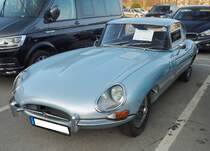Jaguar E-Type Series 1 Coupe. Der E Type, ein Klassiker par excellence im Farbton lavender blue. Vorgestellt auf dem Genfer Salon des Jahres 1961. Wie schon 13 Jahre zuvor der XK120 stieß auch der E Type in der Fachpresse auf einhellige Begeisterung. Sowohl Cabriolet, als auch das FHC (Fixed Head Coupe) genannte, geschlossene Modell waren sofort der Traumwagen der breiten, automobilen Masse. Obwohl die Warteliste bzw. Lieferzeit lang war, bot der damalige Jaguar-Boss William Lyons den Wagen zu einem unerwartet günstigen Preis an. Der Sechszylinderreihenmotor des Series I hat einen Hubraum von 3781 cm³ und leistet 265 PS. Die Höchstgeschwindigkeit des Series I betrug 237 km/h. Besucherparkplatz der Techno Classica Essen am 26.03.2022.