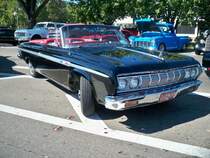 Plymouth Fury Convertible aus dem Jahr 1964 im Farbton ebony. Von diesem Cabriolet-Modell setzte die Chrysler-Division Plymouth in diesem Modelljahr lediglich 5173 Fahrzeuge ab. Die meisten Fahrzeuge dieser Baureihe, wurden mit dem 318 cui (5211 cm³) V8-Motor und einer Leistung von 230 PS bestellt. Das Dreigangautomaticgetriebe dieses Autos wird mittels Drucktasten im Armaturenbrett bedient. Oldtimertreffen der Magnolia Classic Cruiser in Pascagoula/Jackson County/Mississippi im September 2021.