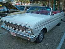 Ford Falcon Futura Convertible aus dem Modelljahr 1964 im Farbton wimbledon white. Im Jahr 1959 brachte Ford, als Antwort auf die Absatzkrise von 1958, das Kompaktmodell Falcon auf den Markt. Der Falcon und sein Schwestermodell Mercury Comet waren für US-Verhältnisse eher Kleinwagen. Wie, in den USA üblich, kam fast jedes Jahr ein neues Modell jeder Baureihe auf den Markt. Ein solches 1964´er Cabriolet stand mit einem Basispreis von US$ 2481,00 in den Preislisten der Ford-Dealer. Basismotorisierung für das Cabriolet war ein Sechszylinderreihenmotor mit einem Hubraum von 3273 cm³ und einer Leistung von 118 PS. Gegen Aufpreis konnte ein V8-Motor mit einem Hubraum von 4728 cm³ und einer Leistung von 200 PS geordert werden. Oldtimertreffen der Magnolia Classic Cruiser in Pascagoula/Jackson County/Mississippi im September 2021.