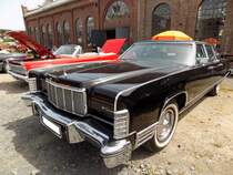 Lincoln Continental Mark IV Limousine aus dem Jahr 1976, in der besonders luxuriösen Ausstattungsvariante Town-Car. Als die US-Autohersteller Mitte der 1970´er Jahre mit dem so genannten  downsizing  anfingen, war die Luxusmarke aus dem Ford-Konzern der einzige Hersteller, der diesen Trend nicht mit machte. Die Coupes und Limousinen von Lincoln hatten weiterhin die gewohnten Dimensionen. Der V8-Motor hat einen Hubraum von 7536 cm³ und leistet 202 PS. Die Höchstgeschwindigkeit wurde mit 190 km/h angegeben und für die  Sparfüchse  unter uns, der Verbrauch stieg dann auf 25 Liter pro 100 Kilometern. Oldtimertreffen an der  Alten Dreherei  in Mülheim an der Ruhr am 18.06.2022.