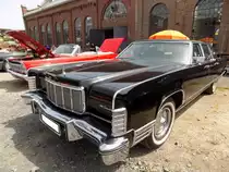 Lincoln Continental Mark IV Limousine aus dem Jahr 1976, in der besonders luxuriösen Ausstattungsvariante Town-Car. Als die US-Autohersteller Mitte der 1970´er Jahre mit dem so genannten  downsizing  anfingen, war die Luxusmarke aus dem Ford-Konzern der einzige Hersteller, der diesen Trend nicht mit machte. Die Coupes und Limousinen von Lincoln hatten weiterhin die gewohnten Dimensionen. Der V8-Motor hat einen Hubraum von 7536 cm³ und leistet 202 PS. Die Höchstgeschwindigkeit wurde mit 190 km/h angegeben und für die  Sparfüchse  unter uns, der Verbrauch stieg dann auf 25 Liter pro 100 Kilometern. Oldtimertreffen an der  Alten Dreherei  in Mülheim an der Ruhr am 18.06.2022.