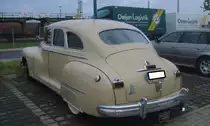 Heckansicht eines Dodge Custom 24 Six aus dem Jahr 1946 im Farbton panama sand. Dieses Modell basiert auf dem Vorkriegsmodell D22 Six, das im Jahr 1942 aufgrund des Kriegseintritts der USA in WW2 eingestellt wurde. Das Modell Custom hebt sich vom deLuxe Modell durch eine höherwertigere Innenausstattung und den verchromten Frontscheibenrahmen ab. Der Sechszylinderreihenmotor hat einen Hubraum von 3772 cm³ und leistet 102 PS. Die Höchstgeschwindigkeit wurde damals mit ca. 130 km/h angegeben. Zollhof Celle.