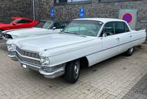 Cadillac Series 62 six window Sedan aus dem Jahr 1964 im Farbton aspen white. Im Modelljahr 1964 bekamen alle Cadillacs den sogenannten  Doppeldecker-Kühlergrill . Alles Modelle dieses Jahrganges waren mit einem neu entwickelten V8-Motor ausgerüstet, der aus einem Hubraum von 7030 cm³ 340 PS leistet. Für das Vergnügen, einen solchen Cadillac sein Eigen zu nennen, musste man mindestens US$ 5191,00 auf die Theke des Cadillac-Dealers legen. US-Cartreffen am Creativ-Quartier-Fürst-Leopold in Dorsten am 10.07.2022.