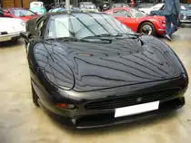 Jaguar XJ220. Der im Oktober 1988 auf der Automobilausstellung in Birmingham gezeigte Prototyp wurde von der Presse und dem Publikum begeistert aufgenommen. Die Auslieferung der 350 produzierten Fahrzeuge erfolgte von 1992 bis 1994. Die Ausstattung des Sportwagens war spartanisch. Es gab kein ABS, keine Servolenkung und noch nicht einmal ein servounterstützte Bremsanlage. Der Antrieb erfolgt durch einen V6-Motor mit doppelter Turboaufladung. Dieser  Sechsender  hat einen Hubraum von 3498 cm³ und leistet 549 PS. Die Höchstgeschwindigkeit gab die Marke aus Coventry mit 349 km/h an. Classic Remise Düsseldorf am 12.07.2022.
