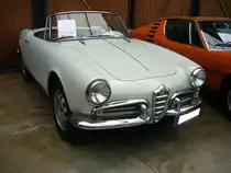 Alfa Romeo Giulietta Spider, gebaut von 1955 bis 1962. Die Alfa Romeo Baureihe 750 wurde bereits im Jahr 1954 vorgestellt. Auf Initiative des USA-Importeurs Maxi Hoffmann (Er war auch der Visionär zur Entwicklung des Mercedes Benz 190SL) wurde ein Jahr später der Spider auf den Markt gebracht. Der Vierzylinderreihenmotor hat einen Hubraum von 1290 cm³ und leistet 65 PS bzw. 90 PS in der Version Spider Veloce. Dieser Spider, im Farbton grigio escoli, wurde 1961 produziert und verbrachte seine  Autojugend  in New York. Classic Remise Düsseldorf am 12.07.2022.