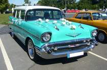 Chevrolet Series 2100B Beauville Station Wagon aus dem Jahr 1957 im Farbton cascade green. Der Series 2100B Beauville Station Wagon konnte mit zwei Sitzbänken (sechssitzig) oder mit drei Sitzbänken (neunsitzig) bestellt werden. Der Basispreis für ein sechssitziges Modell betrug US$ 2456,00 und verkaufte sich in diesem Modelljahr 27.803 mal, während das neunsitzige Fahrzeug US$ 2563,00 kostete und sich 21.083 mal verkaufte. Am großen V auf der Motorhaube ist erkennbar, das dieses Kombimodell mit mit einem V8-Motor bestückt ist. Dieser hat einen Hubraum von 4.635 cm³ und war in sechs Leistungsvarianten lieferbar. Oldtimertreffen am Flughafen Essen/Mülheim am 07.08.2022.