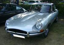 Jaguar E Type Series II Coupe im Farbton silver gray (gray steht tatsächlich so in der Farbkarte), gebaut in Coventry von 1966 bis 1971. Die Series II Fahrzeuge lösten bereits 1964 die Series I Modelle ab. Erst 1966 wurde der Roadster durch ein 2+2 sitziges Coupe-Modell hinzu. Der gezeigte E Type dürfte ein US-Reimport sein, äußerlich erkennbar an den fehlenden Scheinwerferabdeckungen aus Plexiglas. Technisch wurde der Sechszylinderreihenmotor auf einen Hubraum von 4235 cm³ aufgebohrt. Die Motorleistung von 269 PS gegenüber dem Series I Modell änderte sich allerdings nicht. 8. Oldtimertreffen des AMC Duisburg am 04.09.2022.