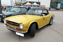 Triumph TR6 im Farbton mimosa yellow, produziert in den Jahren von 1970 bis 1975. Im Jahr 1970 erschien der letzte Abkömmling der klassischen Triumph TR-Baureihe in Form des TR6. Die Karosserie hatte der legendäre Giovanni Michelotti (*1921 +1980) gezeichnet. Der Sechszylinderreihenmotor des TR6 stammt vom Triumph 2000 und wurde auf 2498 cm³ Hubraum aufgebohrt. Dieser Motor leistet 150 PS und beschleunigt den TR6 auf eine Höchstgeschwindigkeit von 190 km/h. Rheinpromenade Köln am 24.09.2022.