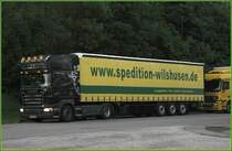 Dieser SCANIA TOPLINE R420 der Spedition Wilshusen fllt durch seine gelben Scheinwerfer auf. Rasthof Sauerland-West. (20.05.2009)
