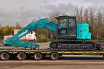Nagelneuer Kobelco SK 140 SG LC, Kettenbagger, steht gut gesichert auf einem Tieflader. 11.2022 