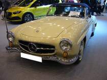 Mercedes Benz W121 BII, gebaut in den Jahren von 1955 bis 1963. Besser bekannt unter der Typenbezeichnung 190SL. Genau 25.881 Fahrzeuge (davon 2246 im Jahr 1962) dieses Typs verließen die Werkshallen von Mercedes Benz. Dieser, im Farbton cremeweiß lackierte Wagen, stammt aus dem Jahr 1962. Der Vierzylinderreihenmotor mit einem Hubraum von 1897 cm³ leistet 105 PS. Für einen solchen  Wirtschaftswunder-Sportwagen  waren mindestens DM 16.500,00 fällig. Ab September 1959 konnte der Kunde bzw. die Kundin ein festes Hardtopcoupedach mit bestellen, um im Winter ein festes Dach über dem Kopf zu haben. Dieser  Luxus  kostete noch einmal zusätzlich DM 1.150,00. Essen Motor Show am 06.12.2022.