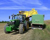 Allradschlepper John Deere 6155R und Ropa Keiler II, Kartoffelvollernter entlädt die gebunkerten Kartoffeln ins Transportfahrzeug, Aug.2022