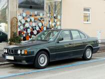 BMW-530i in einer Kurzparkzone, während die Fahrgäste den angrenzenden Sozialmarkt stürmen; 220203