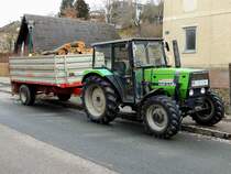 DEUTZ-FAHR DX3-10; transportiert am mitgeführten Einachskipper gefällte Baumstämme ab; 220211