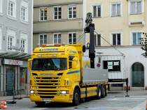 SCANIA R560 hievt mit dem angebauten Hydraulikkran einen Baustellencontainer zum geplanten Aufstellungsort; 220708