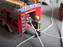 Eine Feuerwehrmann bedient die Pumpe an einem LF 16.
Szene aus meinem Diorama  Brauereibrand . Das Feuerwehrfahrzeug ist ein Bausatz von Preiser, der Feuerwehrmann ist selbst bemalt. Aufgenommen am 7.5.2005.