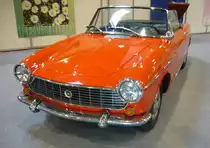 Fiat 1500 Spider aus dem Jahr 1966 im Farbton rosso. Produziert wurde der Spider in den Jahren von 1963 bis 1966. Das hübsche Blechkleid wurde von Pininfarina geschneidert. Der Vierzylinderreihenmotor hat einen Hubraum von 1481 cm³ Motor und leistet 67 PS. Ab dem Modelljahr 1964 wurde die Leistung auf 75 PS erhöht. Die Fahrzeuge mit 75 PS waren serienmäßig mit einem Fünfganggetriebe ausgerüstet. Techno Classica Essen am 13.04.2023.