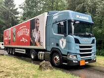 Der Scania Sattelzug mit dem Trauffer Trailer von Planzer am 30.6.23 an der Hauptstrasse bei Münchenbuchsee parkiert.