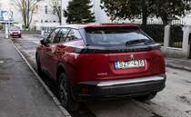 Diesen Peugeot 2008 Mk2 in Rouge Elixir (Elixir Red oder Elixir Rot) habe ich  in Januar, 2022 von hinten fotografiert.