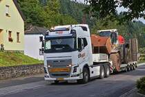 Volvo Schwerlastsattelzug mit einem Cat Radlader, aufgenommen nahe einer Bahnbaustelle in Enscherange. 25.08.2023

