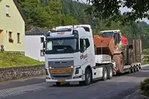 Volvo Schwerlastsattelzug mit einem Cat Radlader, aufgenommen nahe einer Bahnbaustelle in Enscherange. 25.08.2023

