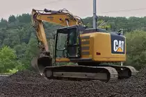 Caterpillar Raupenbagger wartet an der Schotterverladestelle, an der Bahnbaustelle nahe Drauffelt, auf den nächsten LKW zum beladen mit dem alten Schotter. 08.2023

