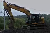 Caterpillar Raupenbagger wartet an der Schotterverladestelle, an der Bahnbaustelle nahe Drauffelt, auf den nächsten LKW zum beladen mit dem alten Schotter. 08.2023

