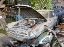 =Borgward Isabella steht im Schrottplatzdiorama vom Zylinderhaus in Bernkastel-Kues, 04-2023. 