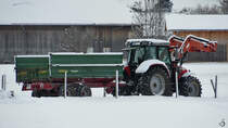 Ein Massey-Ferguson-Traktor mit einem Anhänger, so gesehen Ende November 2023 in Pfronten.