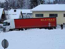 DAF-480 X63 aus Litauen mit BLEIRAS-Logistic Auflieger hat sich trotz einigen Fahrverboten sowie auch ohne Schneeketten vorgewagt, und ist in einer Siedlung steckengeblieben, und wartet nun Stundenlang festgefressen, eine Zufahrtstrasse blockierend, auf Hilfe; 231204