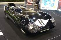Lotus Eleven aus dem Jahr 1956. Der Wagen trug ursprünglich die Typenbezeichnung  Mark 11 , wurde aber von der Motorpresse schnell als Lotus Eleven bezeichnet. Lotus übernahm dann diese Typenbezeichnung. Frühe Lotus-Fahrzeuge trugen ihre Mark-Typennummern teilweise auch in römischen Zahlen, so das die  11  auch als  II  gelesen werden konnte. Um Verwirrungen zu vermeiden, wurde beschlossen, es zu buchstabieren. So wurde das Auto zum Lotus  Eleven  und führte somit unbeabsichtigt die  E-Namenspolitik  für alle nachfolgenden Lotus-Straßenfahrzeuge ein. Lotus-Gründer Colin Chapman (*1928 +1982) selbst nahm mit einem solchen  Eleven  an den 24 Stunden von LeMans in der 1500 cm³-Klasse teil, musste aber aufgeben. Der Vierzylinderreihenmotor aus dem Hause Coventry-Climax hat einen Hubraum von 1460 cm³ und leistet 149 PS. Essen Motorshow am 06.12.2023.
