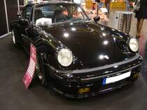 Porsche 911 Turbo Coupe aus dem Jahr 1985. Im August 1973 wurde die so genannte G-Serie des Porsche 911 vorgestellt. Äußerlich erkennbar an den Faltenbälgen an den Stossfängern und dem roten  Porsche-Leuchtband  am Heck. Hier konnte ich einen 911´er Turbo der letzten Serie, wie er von 1985 bis 1989 gebaut wurde ablichten. Der im Heck verbaute, gebläsegekühlte, Sechszylinderboxermotor hat einen Hubraum von 3299 cm³ und leistet mittels eines Abgas-Turboladers aus dem Hause KKK genau 300 PS. Bei seiner Markteinführung im Februar 1985 kostete ein solcher 911 Turbo mindestens DM 114.000,00. Essen Motorshow am 06.12.2023.