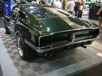 Heckansicht eines Ford Mustang 1 Fastback Coupe des Modelljahres 1967 im Farbton lovelime green. Der Erstbesitzer dieses Fastback Coupes hat auf der Bestellung des Fahrzeuges einer stärkeren Motor, als den Basis V8-Motor angekreuzt. Dieses  Pony  hat einen V8-Motor mit einem Hubraum von 390 cui (6391 cm³) und einer Leistung von 320 PS. Die Höchstgeschwindigkeit ist laut dem Expose am Fahrzeug mit 190 km/h angegeben. Dann fließen ab auch bis zu 17 Liter Benzin auf 100 Kilometer durch die Vergaseranlage. Essen Motorshow am 06.12.2023.