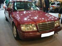 Mercedes Benz W124 200E Cabriolet aus dem Jahr 1994. Die Baureihe W124 wurde Ende des Jahres 1984 vorgestellt. Im Jahr 1991 erweiterte Mercedes Benz um ein Cabriolet auf der Basis des Coupes. Der hier gezeigte 200E im Farbton almandinrot ist mit einem sehr seltenen Hardtopdach ausgerüstet. Motorisiert ist dieses Cabriolet mit dem kleinsten, damals lieferbaren Vierzylinderreihenmotor ausgerüstet. Dieser hat einen Hubraum von 1998 cm³ und leistet 136 PS. Es handelt sich um ein Traditionsfahrzeug eines Essener Mercedes Benz-Händlers. Essen Motorshow am 06.12.2023.